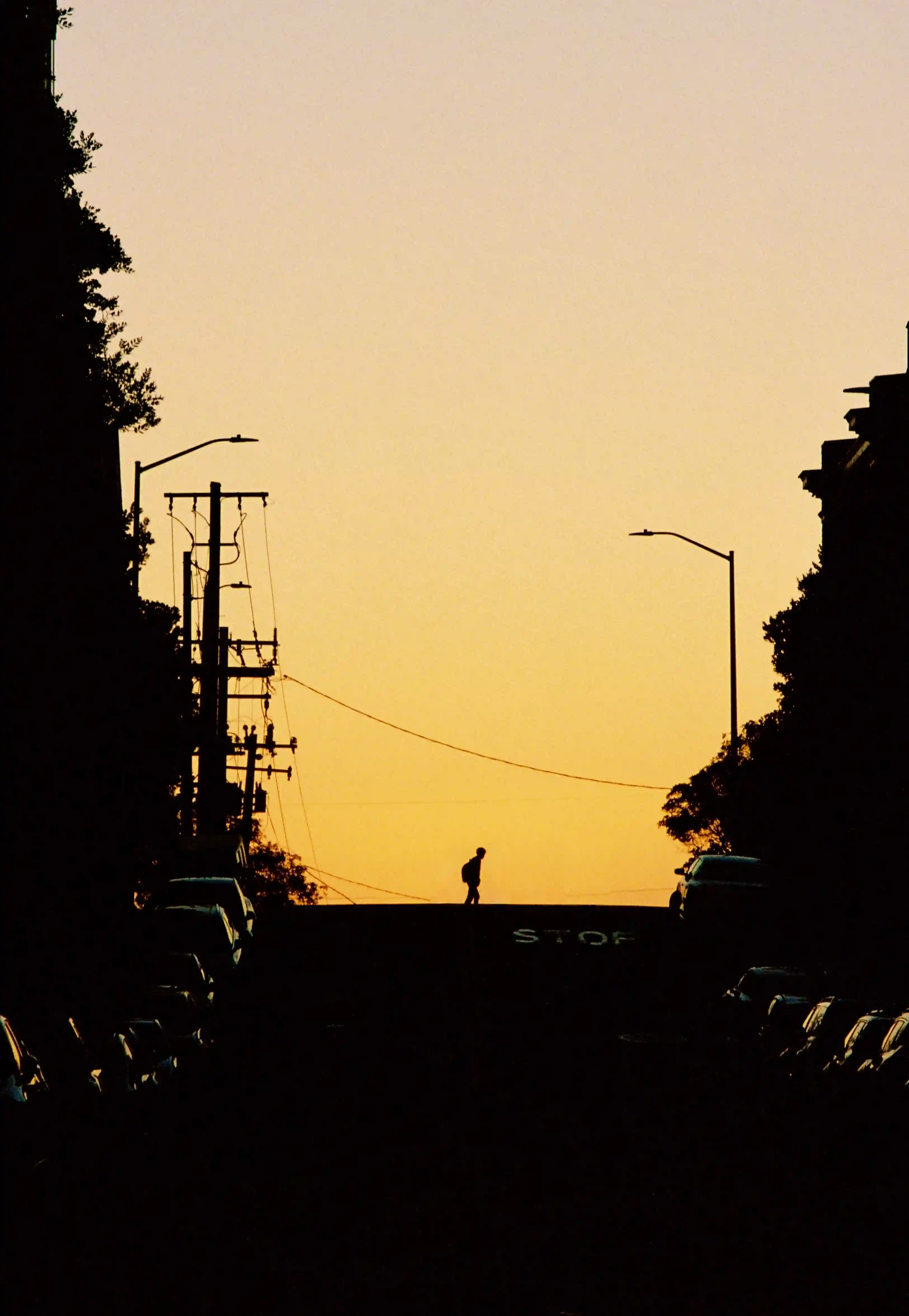 Sunset guy walking over street shadows in front of street
