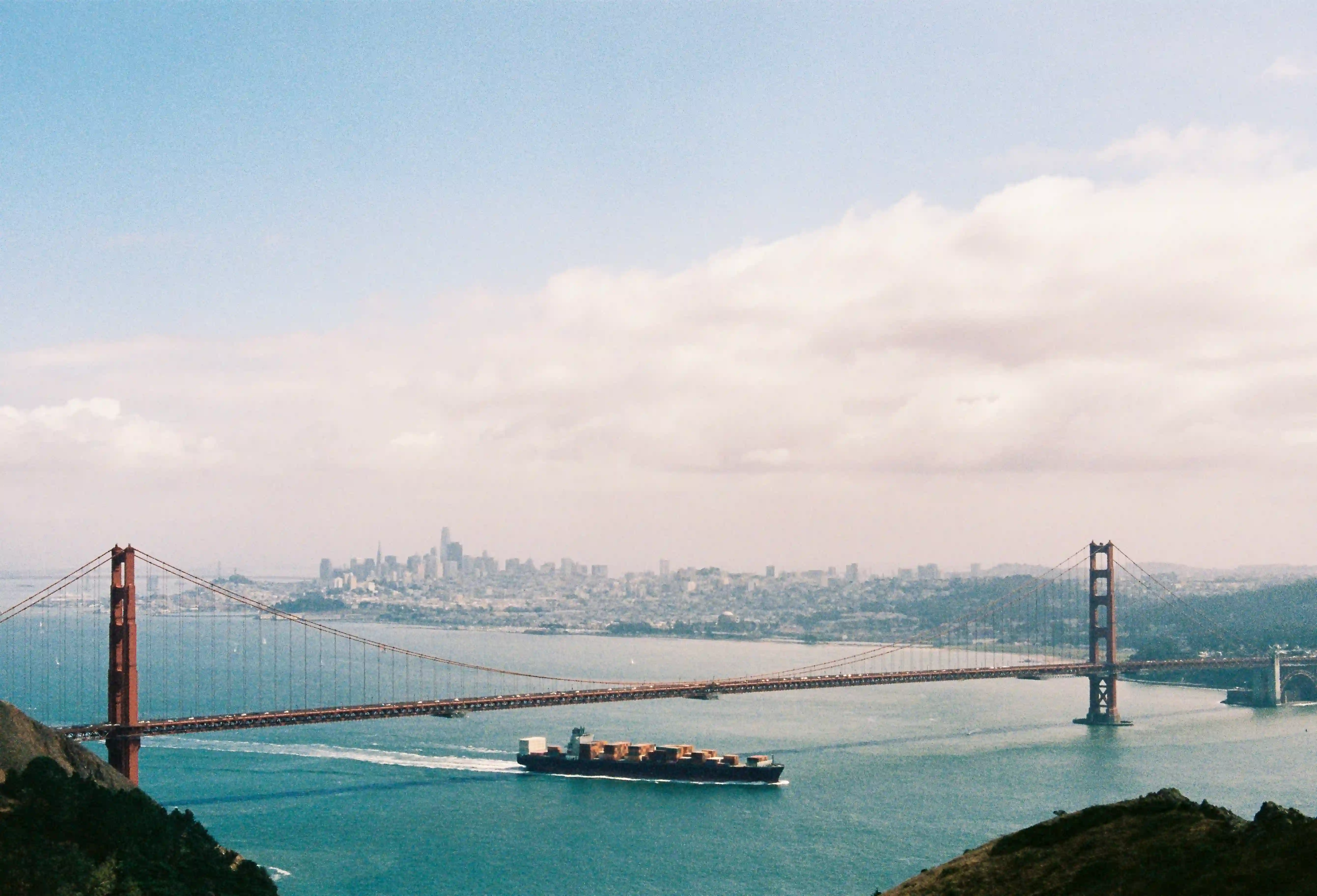 Golden Gate Bridge container ship driving under San Franscisco Sky Line